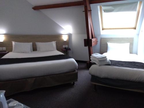 a hotel room with two beds and a window at Kyriad Saint Fargeau Ponthierry - Apollonia in Saint-Fargeau-Ponthierry