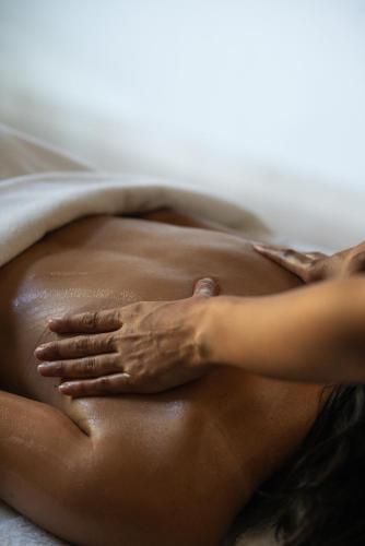 a woman laying on a bed with her hands on her stomach at Four Seasons Hotel Tunis in Gammarth