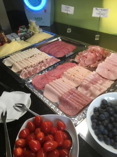 a buffet filled with lots of different types of meats and grapes at Parkhotel Leiser in Planegg