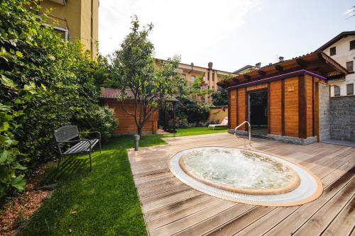 a hot tub on a wooden deck in a yard at Hotel Elena in Saint Vincent