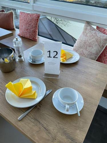 a table with white plates and yellow napkins on it at Parkhotel Leiser in Planegg