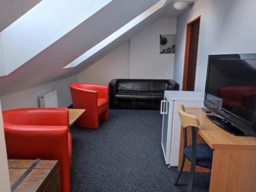 salon z czerwonymi krzesłami i kanapą w obiekcie Penzion a Restaurace Bělecký Mlýn w mieście Ptení