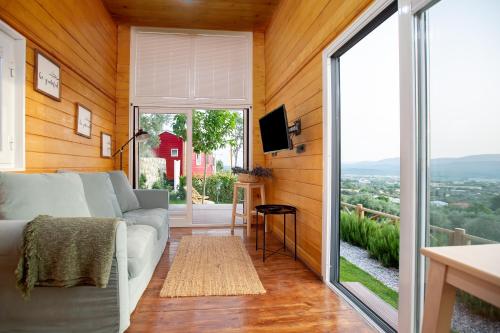 a living room with a couch and a large window at Urlachi Çiftliği in Urla
