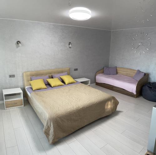 a bedroom with two beds with yellow and purple pillows at Апартаменты LUX в центре. Ярослава Мудрого 72 (97й квартал) in Kryvyi Rih