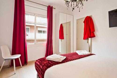 バルセロナにあるApartment Eduardoの赤いカーテン、ベッド1台、椅子が備わるベッドルーム1室が備わります。