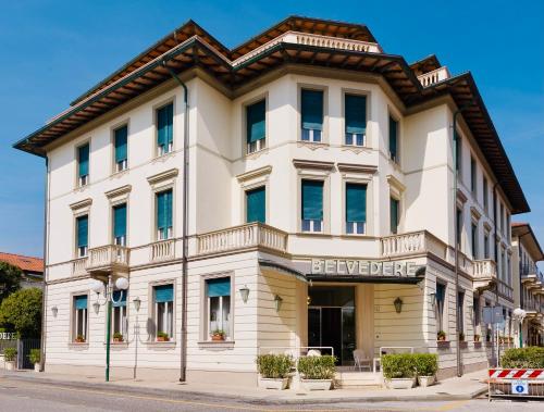 un bâtiment blanc avec un panneau indiquant beverley hotel dans l'établissement Hotel Belvedere, à Forte dei Marmi