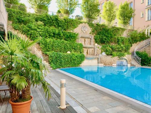 a swimming pool with a wall of ivy at Hotel Maximilian in Bad Griesbach