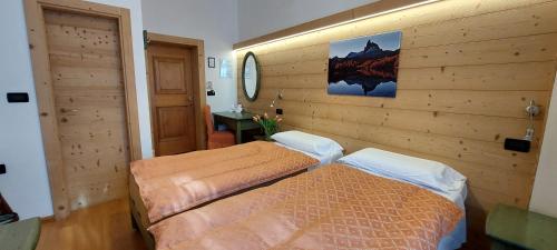a bedroom with a bed and a dresser at Hotel Montana- ricarica auto elettriche in Cortina dʼAmpezzo