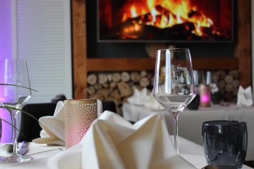 a table with wine glasses on a table with a fireplace at Hotel Sankt Georg in Neubrandenburg