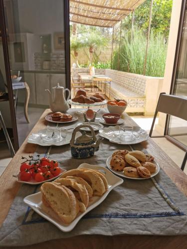 a table with plates of bread and pastries on it at Palazzo Maresgallo Suites & SPA in Lecce