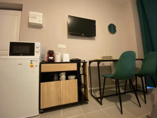 uma cozinha com um frigorífico, uma mesa e uma cadeira verde em NG SuiteHome - Lille I Roubaix Edouard Roussel - Studio - Netflix - Wifi em Roubaix