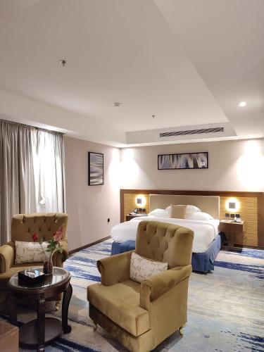 a hotel room with a bed and a couch and chairs at شقق كيان للشقق المخدومه in Jeddah