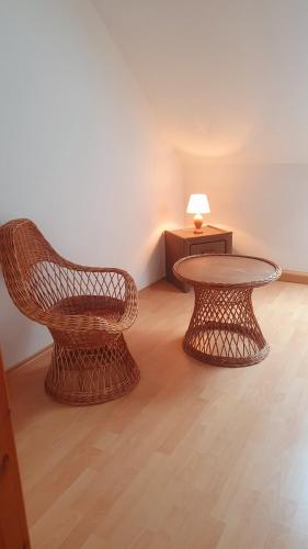 a room with a table and a wicker chair and a coffee table at Haus Müritz, FeWo 12 Möwe in Zielow