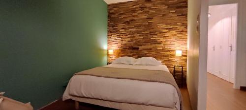 Un dormitorio con una cama con una pared de ladrillos. en ✪ Appt. Rénové - Vue sur mer ✪, en Quiberon