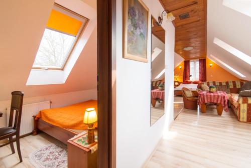 Zimmer mit einem Bett und einem Wohnzimmer in der Unterkunft Dworek w Ogrodzie in Kazimierz Dolny
