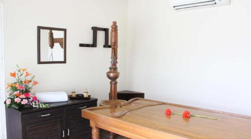 a room with a sink and a table with flowers at Godwin Haridwar in Haridwār
