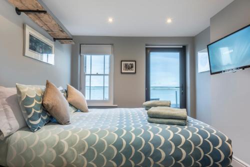 a bedroom with a large bed with a flat screen tv at The Royal George in Appledore