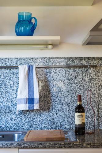 a bottle of wine sitting on a counter next to a sink at Zafferano Rooftop Terrace Tower House in San Gimignano