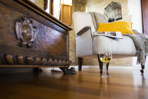a glass of wine sitting next to a chair at Zafferano Rooftop Terrace Tower House in San Gimignano