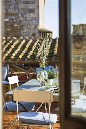 a table with a vase of flowers on it at Zafferano Rooftop Terrace Tower House in San Gimignano