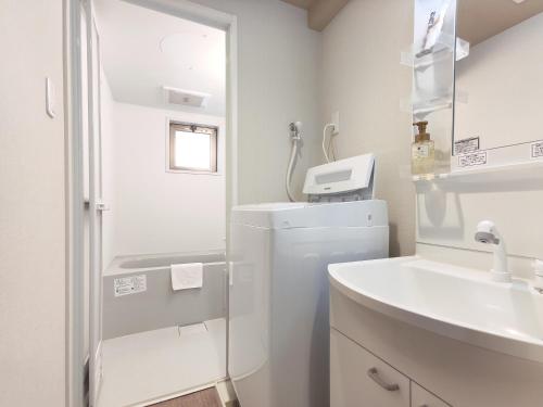 京都的住宿－West Japan Kyoto Kiyomizu，白色的浴室设有水槽和冰箱。