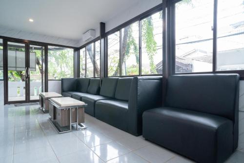 a waiting room with blue leather couches and windows at RedDoorz Plus near ITC Cempaka Mas 2 in Jakarta