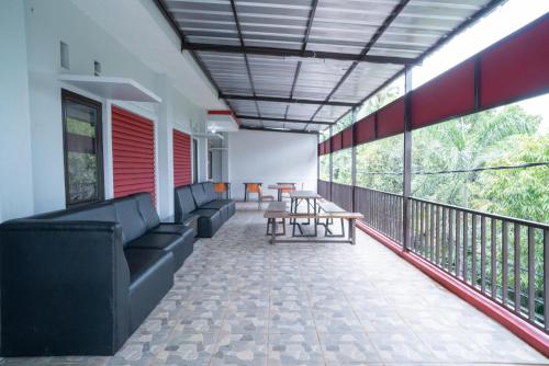 a balcony with couches and tables on a building at RedDoorz Plus near ITC Cempaka Mas 2 in Jakarta