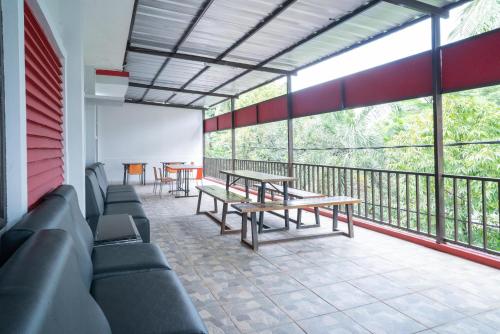 a room with benches and tables on a balcony at RedDoorz Plus near ITC Cempaka Mas 2 in Jakarta