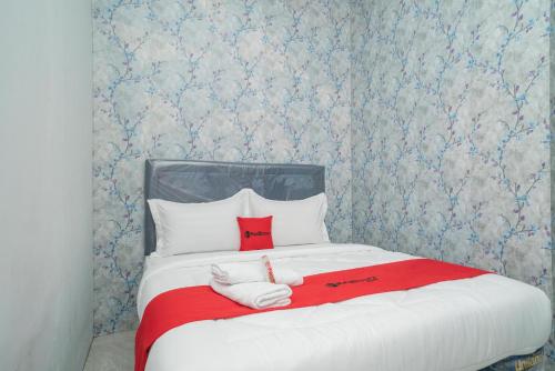 a bedroom with a bed with two towels on it at RedDoorz Plus near ITC Cempaka Mas 2 in Jakarta