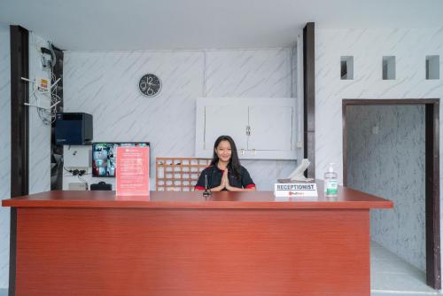 a woman standing behind a counter in a room at RedDoorz Plus near ITC Cempaka Mas 2 in Jakarta