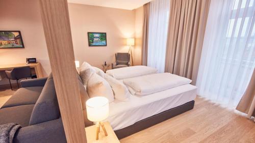 a hotel room with a bed and a couch at Seehotel Maria Laach in Maria Laach
