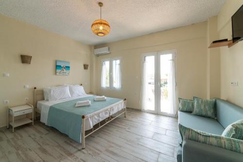 een slaapkamer met een bed en een bank bij Cyclades Luxury Studios in Nea Potidaea