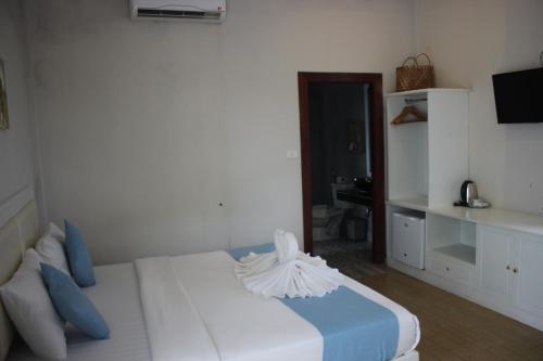 a bedroom with a white bed with blue pillows at Scarlet Sails Resort in Koh Rong Island