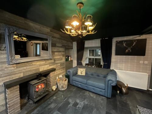 a living room with a blue couch and a fireplace at Taigh Neonach in Watten