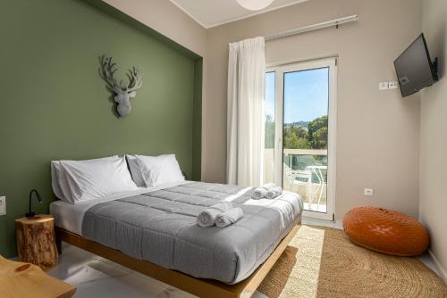 a bedroom with a bed and a large window at Kipos Hotel in Rethymno Town
