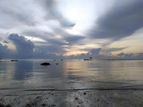 a view of the ocean under a cloudy sky at Flat Japaratinga Beach in Japaratinga