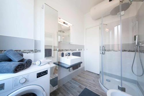 een badkamer met een wasmachine en een wastafel bij Cipriani 5 RivieraHoliday in Pietra Ligure