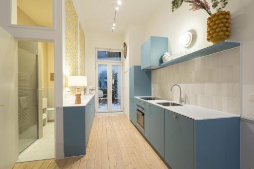 a kitchen with blue cabinets and a sink at Le Lambermont in Antwerp