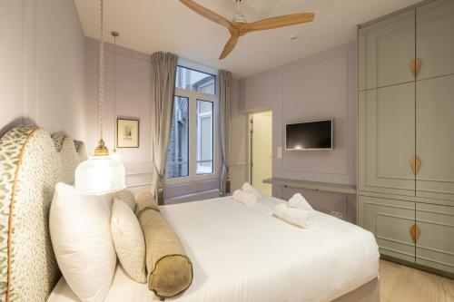 a bedroom with a white bed and a tv at Le Marnix in Antwerp