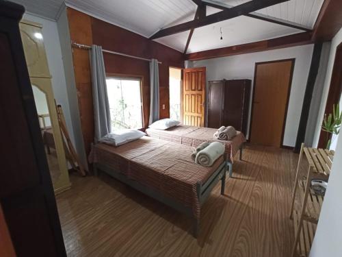 a bedroom with two beds and a window at CASA DA MATA descanso e sossego na natureza in Ibicoara
