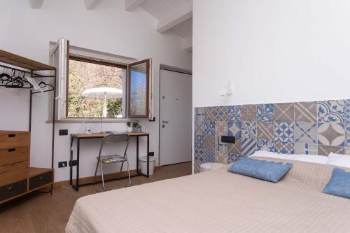 um quarto com 2 camas, uma secretária e uma janela em A06 - Massignano, meravigliosa camera con vista em Massignano