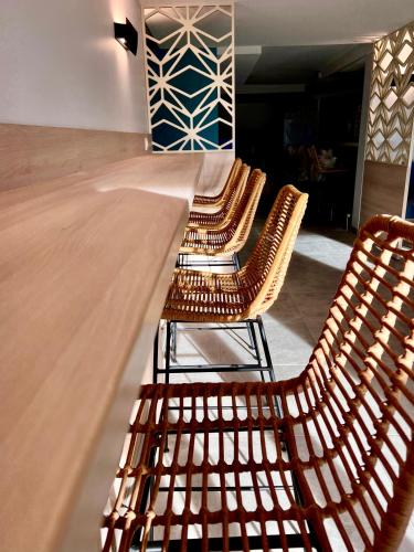 a row of wooden chairs sitting in a room at The Originals City, Hôtel Le Puech, Narbonne in Narbonne