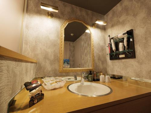 a bathroom with a sink and a mirror on a counter at Fun3 -Adult Only- in Yokohama