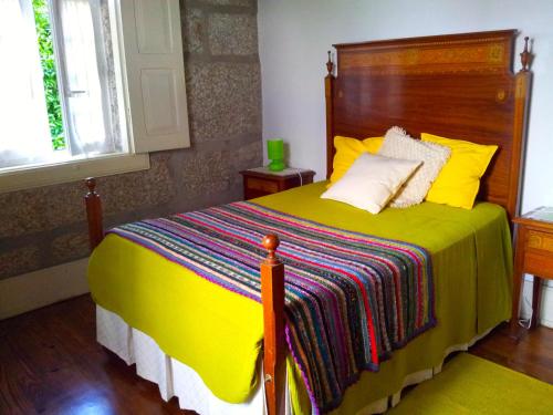 a bedroom with a yellow bed with a colorful blanket at Casa Das Vendas in Vendas