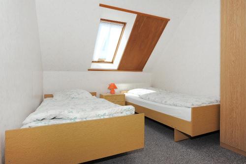 two beds in a small room with a window at Ferienwohnungen auf dem Ferienhof Elke Peters in Holtgast