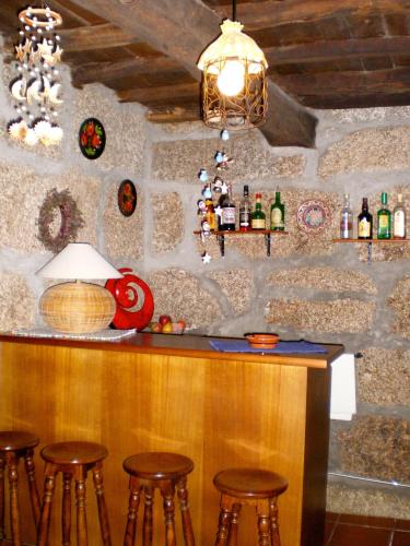 a bar with stools at a stone wall at Casa Das Vendas in Vendas