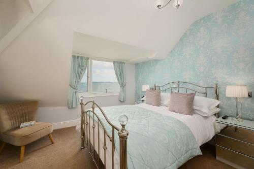 1 dormitorio con 1 cama, 1 silla y 1 ventana en Channel View Boutique Hotel - Adults Only, en Paignton