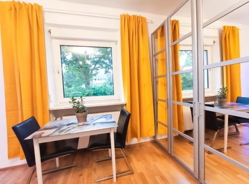 Habitación con 2 mesas y una ventana en Modernes Zimmer am Park mit Garten, Hühner & Enten, en Múnich