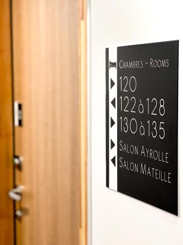 a sign on a door with a clock on it at The Originals City, Hôtel Le Puech, Narbonne in Narbonne