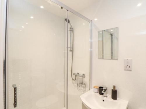 a white bathroom with a shower and a sink at Battell Chambers in Camborne